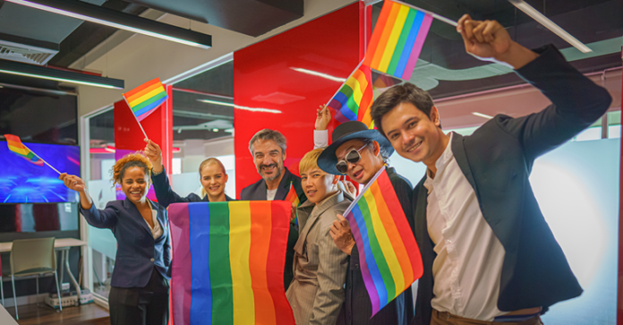 A group of office workers celebrate Pride Month with rainbow flags