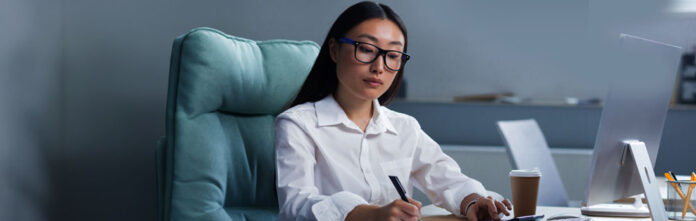 Asian woman sitting at desk working on legal department financial management with  spreadsheets and calculator