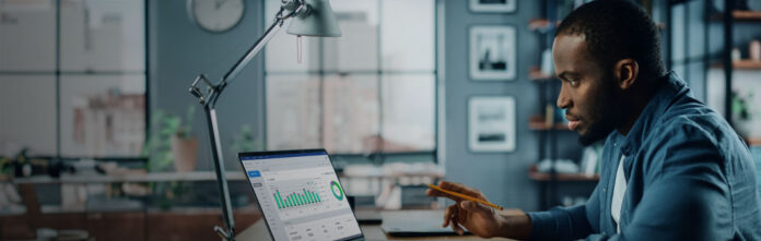 African American man with glasses working with financial reports at his desk, perhaps looking at legal spend management numbers