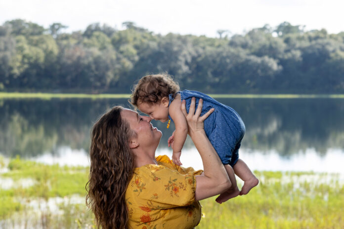 A photo of a mother holding her daughter up to her face.