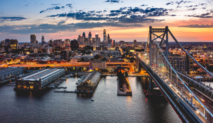 Bridge over a river leading into a lit city