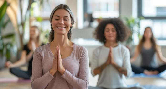 a group of females doing yoga and meditating. Wellness programs aim to improve employee health and well-being. But many miss the mark on inclusivity, potentially doing more harm than good.