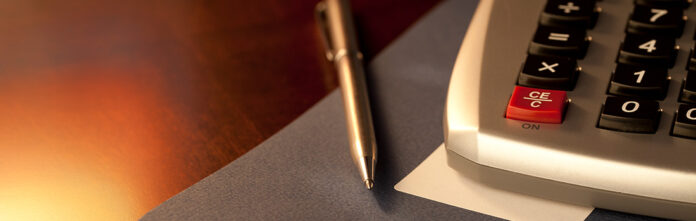 calculator and pen on a desk to help legal operations manage e-billing solutions