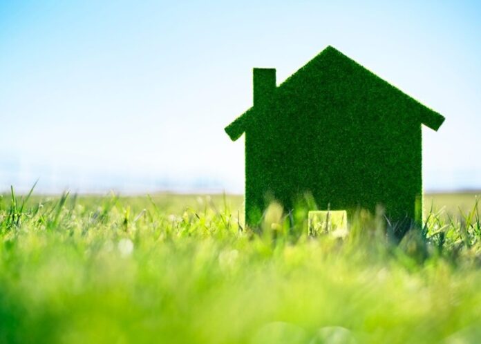 Green eco house in an empty field